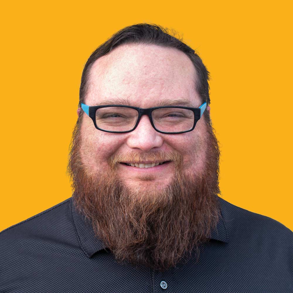 TJ's headshot on a gold background