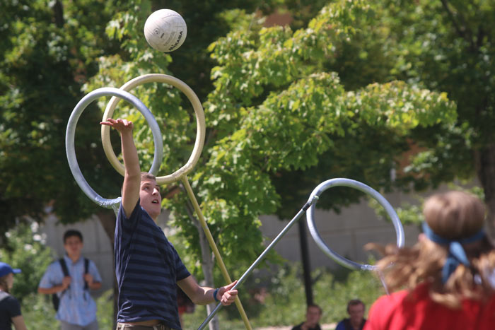 A man jumping to prevent a ball from flying between a goal post