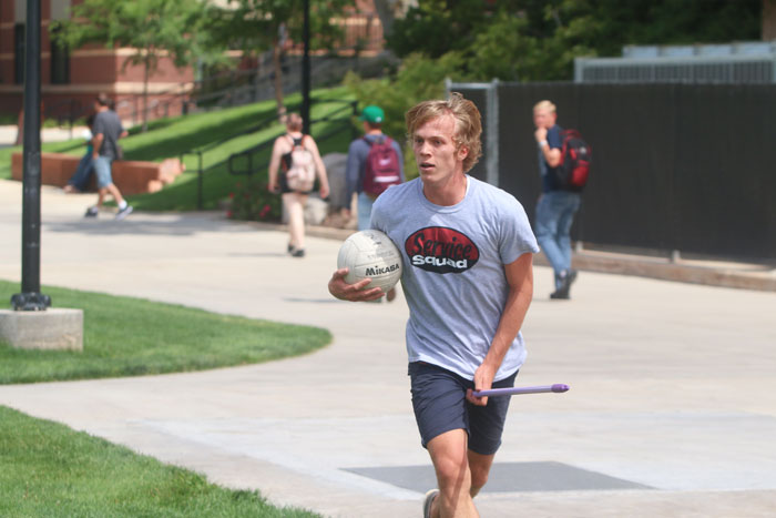 A man holding a ball and running