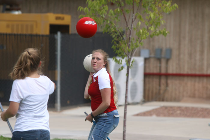 A woman prepares to throw a ball as a dodgeball flies toward her