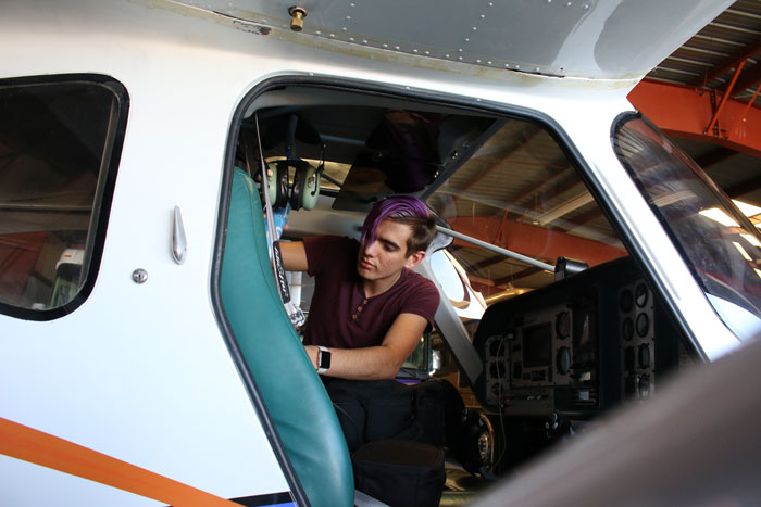 Pilot leaning into an airplane during preflight checks