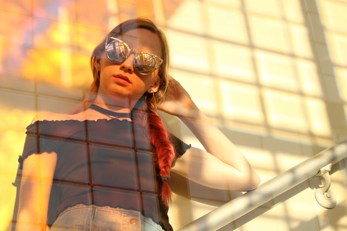 Model posing with light reflecting through glass