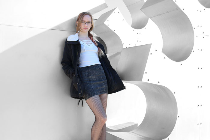 Model leaned against a geometric sculpture